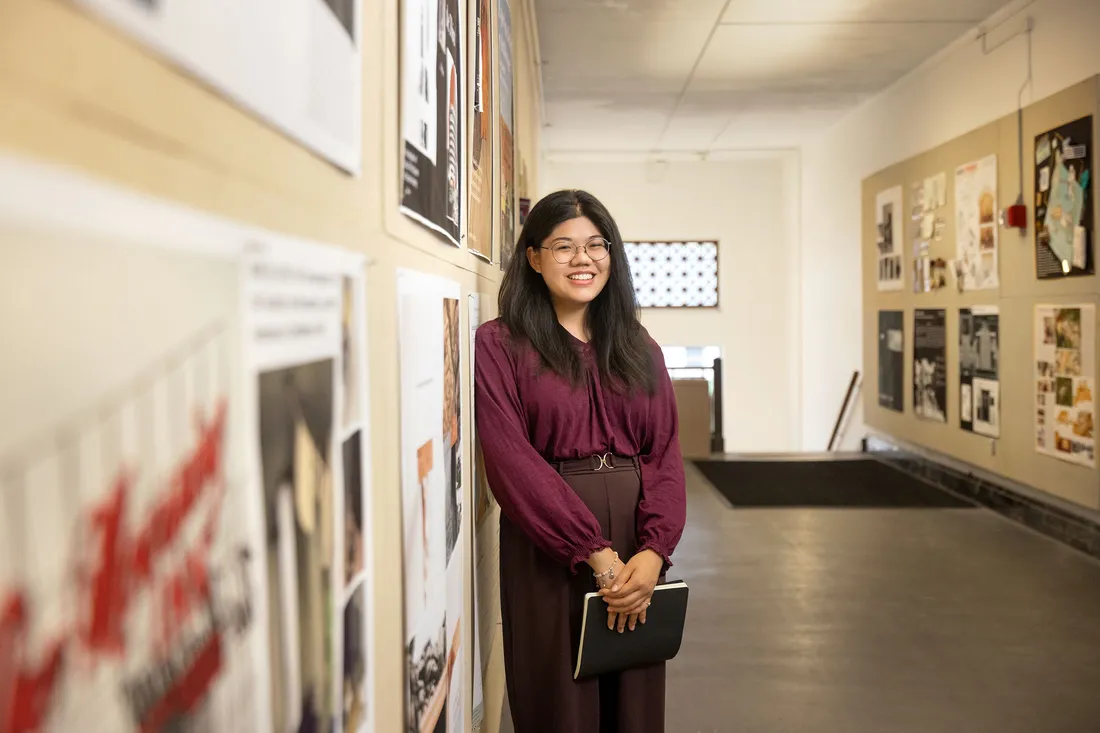 Corrine Soo smiling and standing in a hallway.